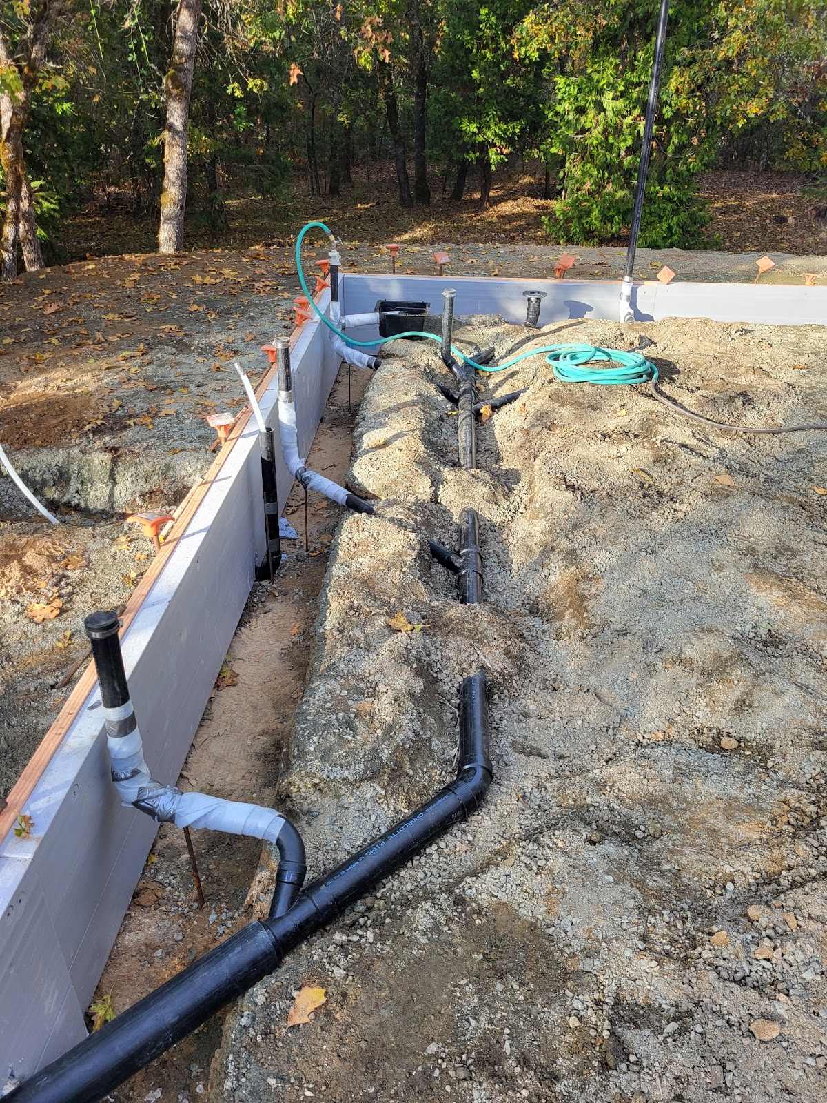 New construction plumbing rough-in trenching along a foundation