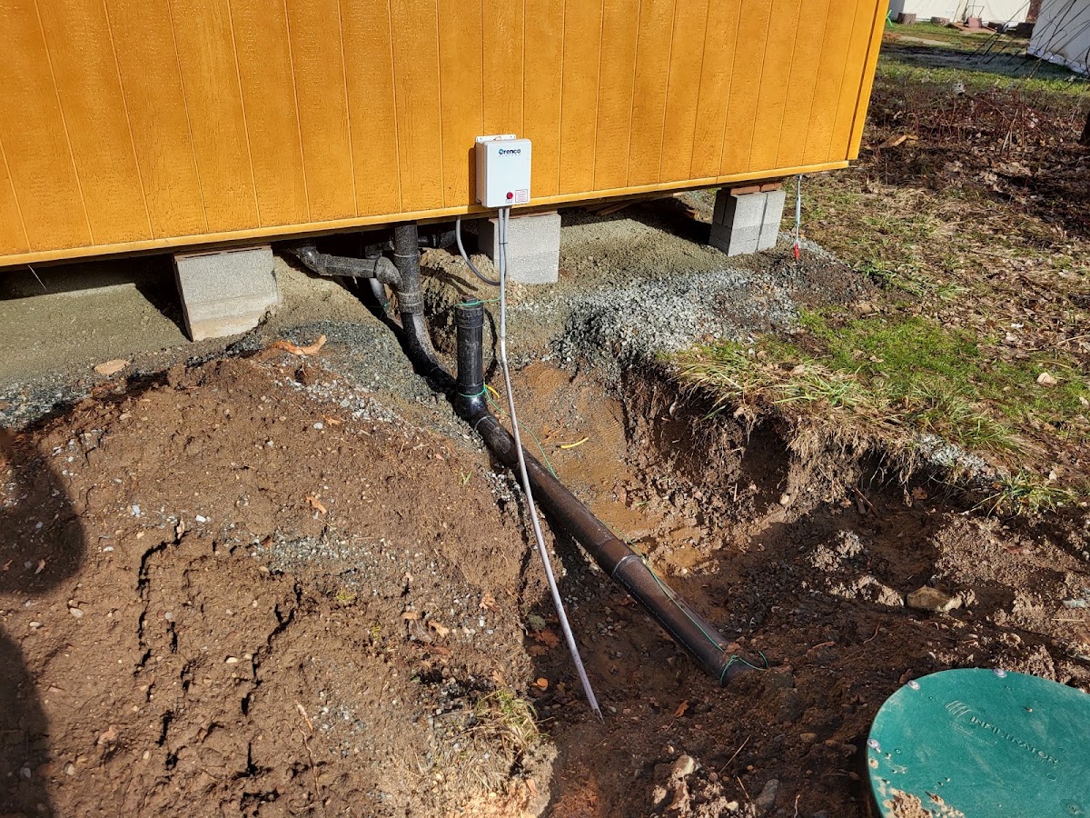 A sewer line repair excavated beside a home's foundation